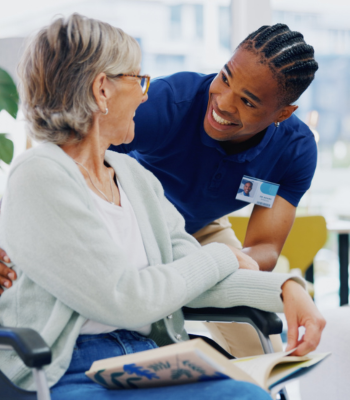 An EverCare caregiver standing warmly with an older client.